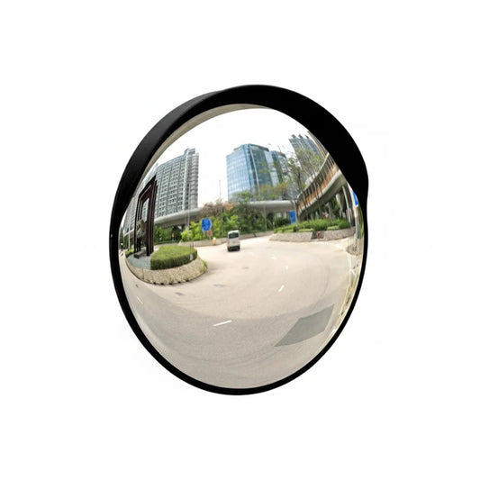 Convex mirror showing a wide view of an urban street with buildings and trees.