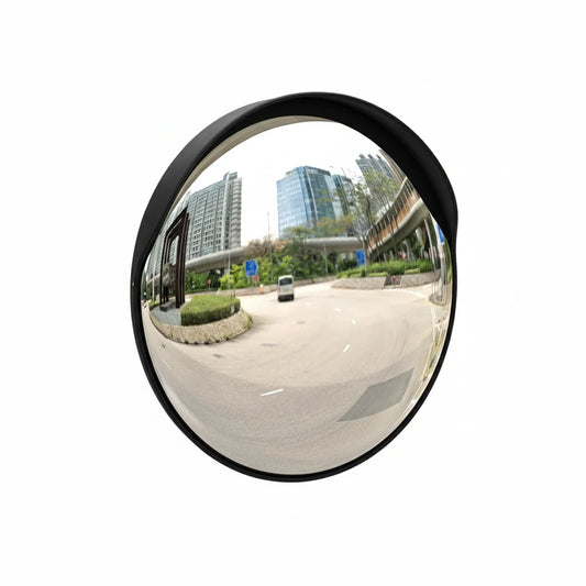 Convex mirror showing a wide view of an urban street with buildings and a car.