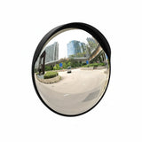 Convex mirror showing a wide view of an urban street with buildings and a car.