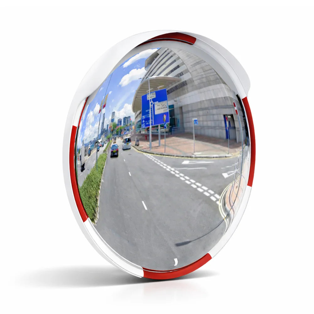 Convex mirror reflecting a road scene with vehicles and buildings.